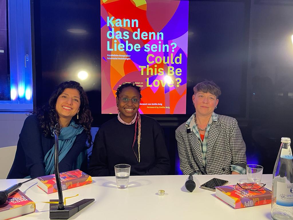 A picture of Aseman G. Bahadori, Ifeatu Nnaobi and Ambika Thompson in front of an image of the book, "Could This Be Love?"